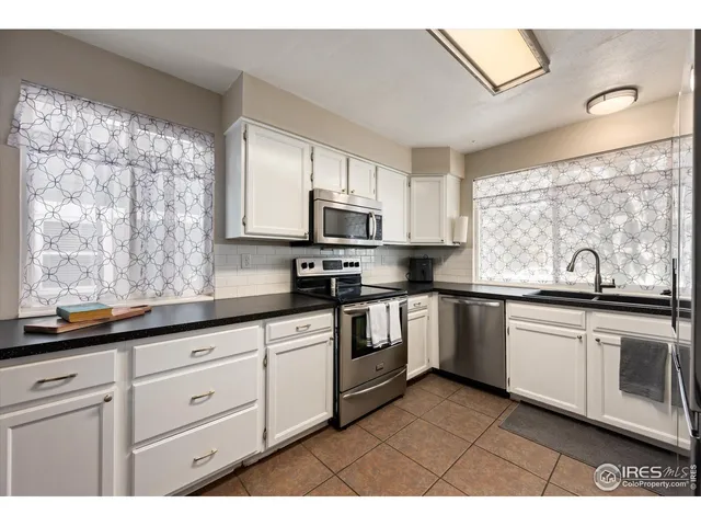 a kitchen with granite countertop white cabinets and appliances