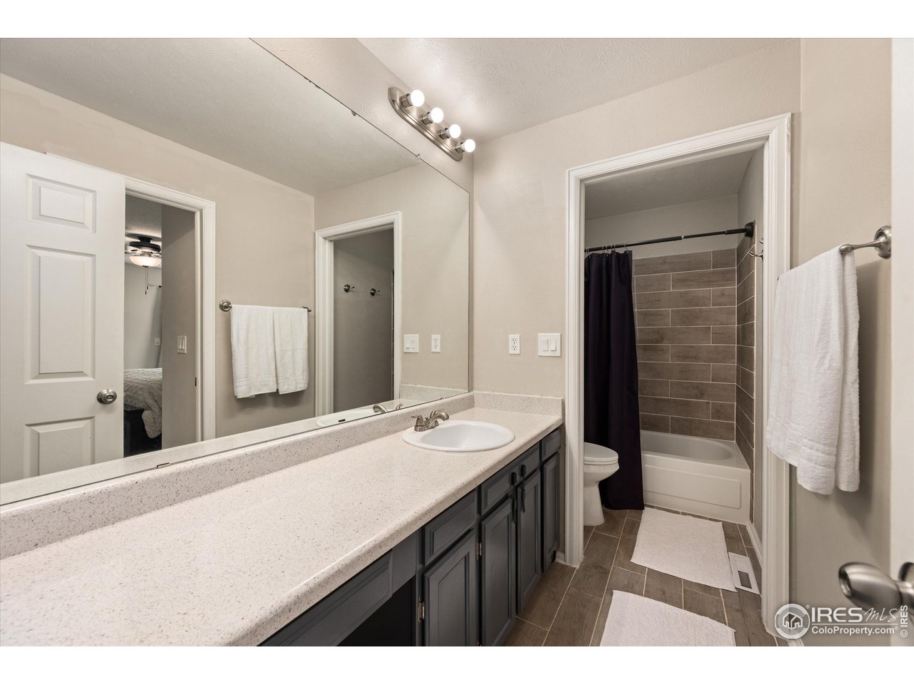 7328 South Gore Range Road Littleton, CO 80127 - Photo 16 of 38 a bathroom with a sink a mirror and a shower