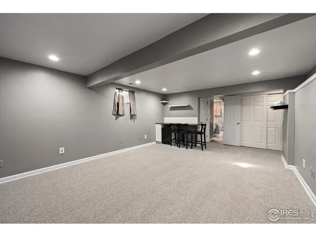 a view of a hall with kitchen and natural light