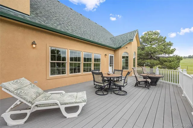 a view of a patio with table and chairs and wooden floor