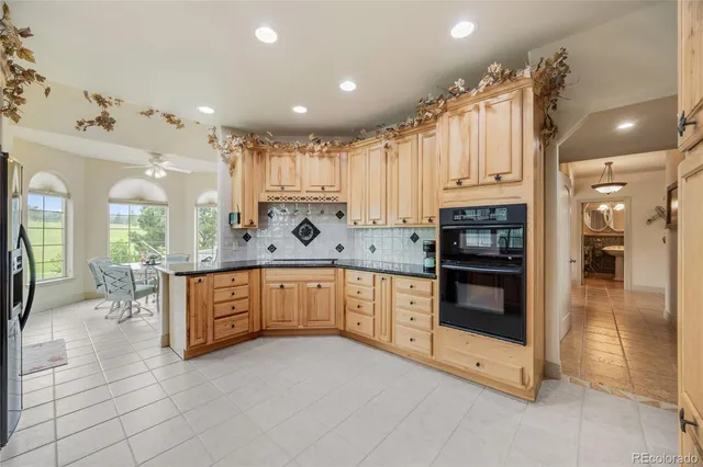 a large kitchen with stainless steel appliances a large counter top a stove a chimney a sink and cabinets