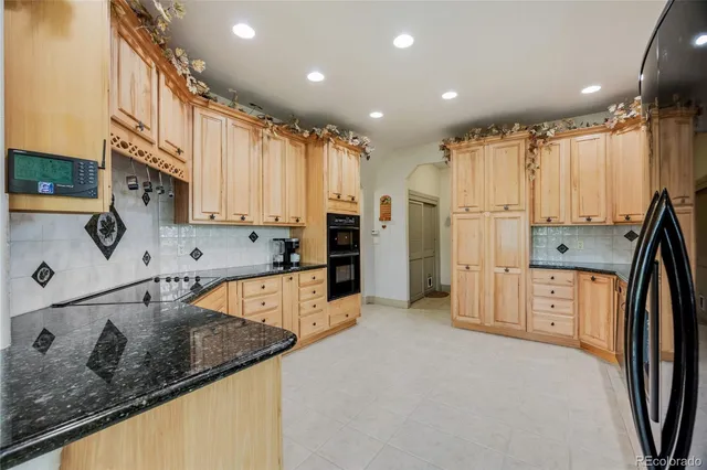 a kitchen with stainless steel appliances granite countertop a sink refrigerator and cabinets