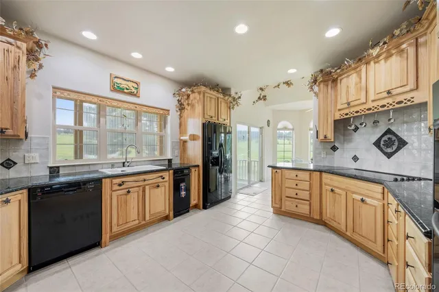 a large kitchen with stainless steel appliances granite countertop a large stove top oven and cabinets