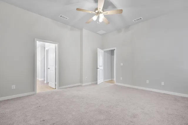 an empty room with fan and entrance