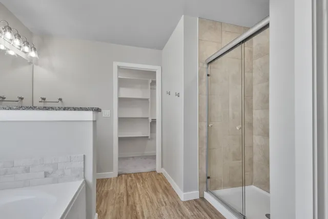 a bathroom with a tub shower vanity and a sink