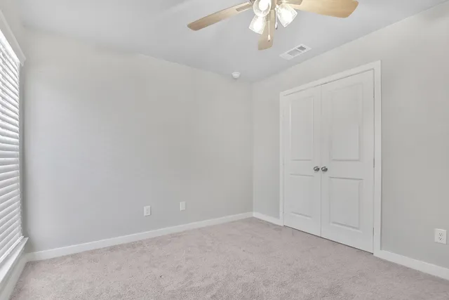 an empty room with a chandelier fan
