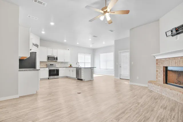 a view of kitchen with refrigerator stove microwave and cabinets