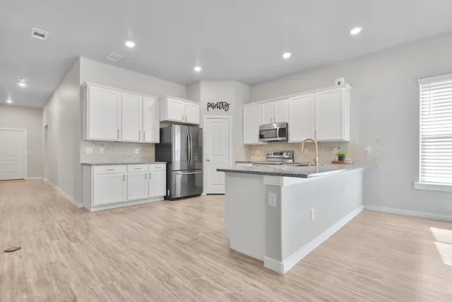 a kitchen with stainless steel appliances a refrigerator sink and microwave
