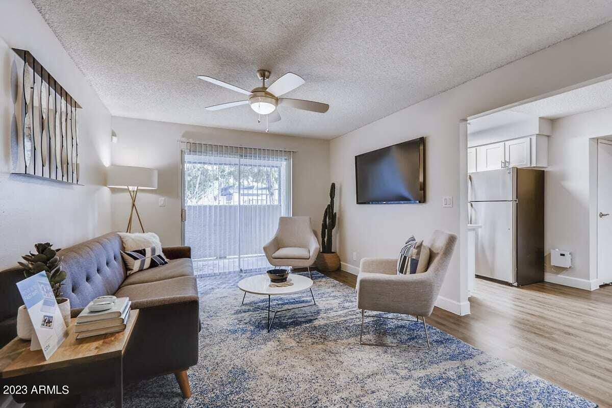 1944 West Thunderbird Road, Unit 2 Phoenix, AZ 85023 - Photo 2 of 14 a living room with furniture a flat screen tv and a table