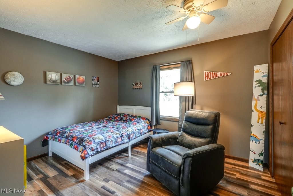 1157 Bass Circle Northwest Canton, OH 44708 - Photo 15 of 31 Bedroom featuring a textured ceiling, a ceiling fan, and wood finished floors