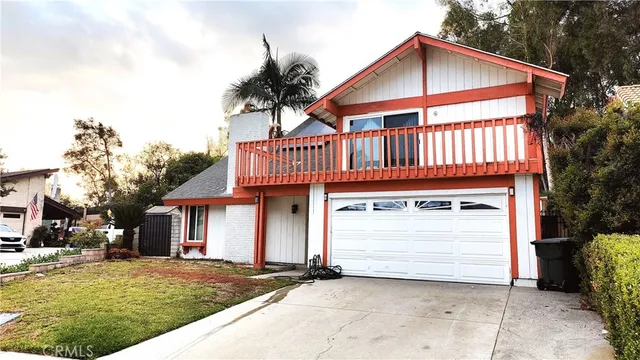 a front view of a house with a garden and trees
