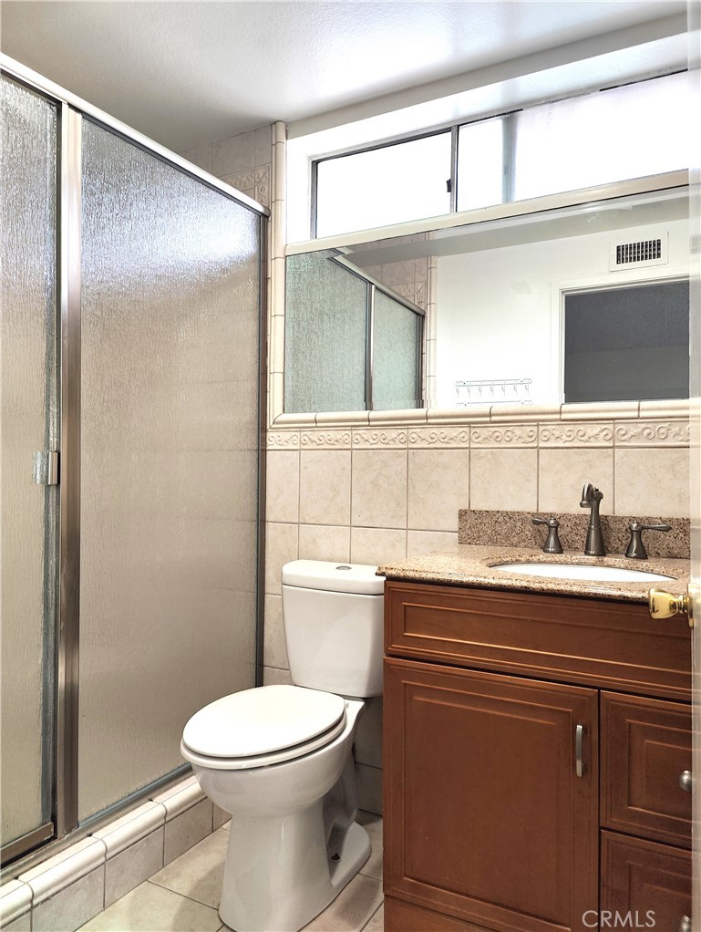 2821 Greenleaf Drive West Covina, CA 91792 - Photo 23 of 32 a bathroom with a granite countertop toilet sink and mirror