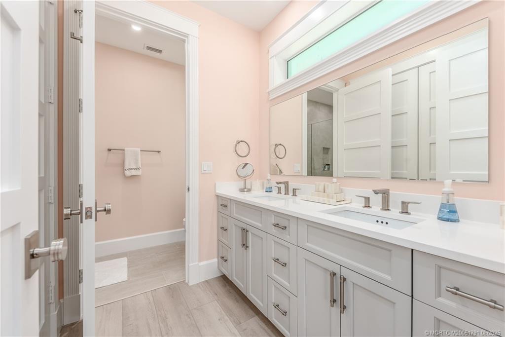 1879 Northwest River Trail Stuart, FL 34994 - Photo 12 of 25 a bathroom with a double vanity sink a mirror and a shower