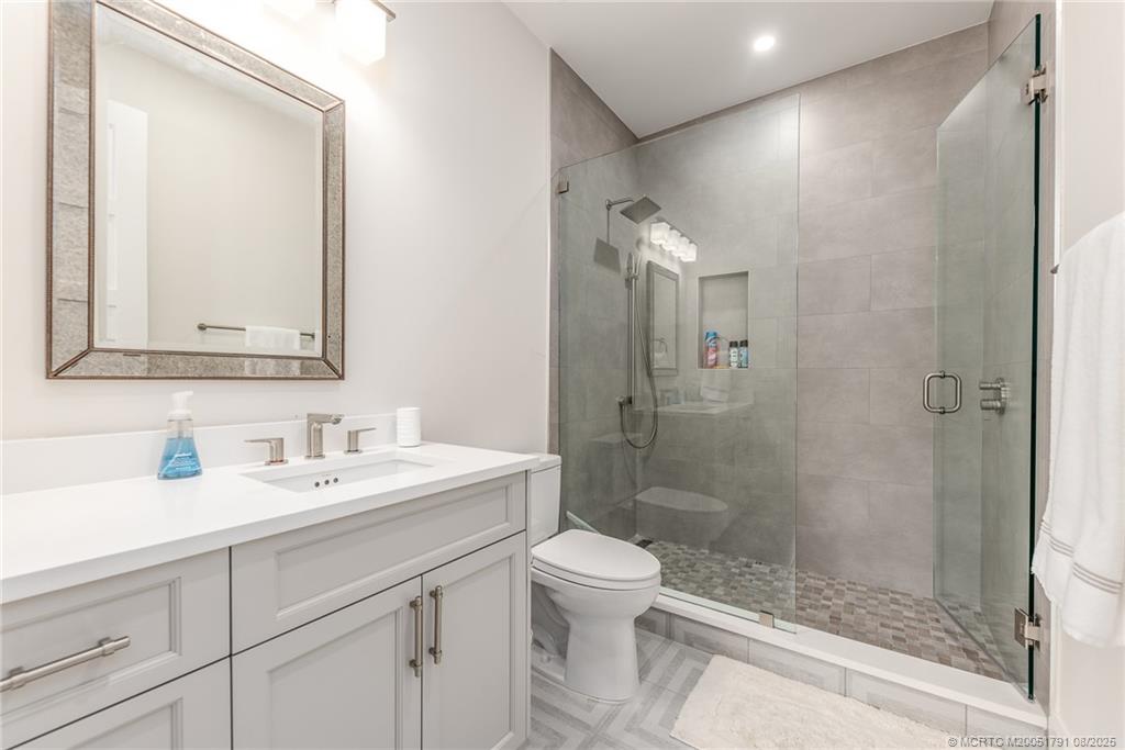 1879 Northwest River Trail Stuart, FL 34994 - Photo 14 of 25 a bathroom with a shower sink vanity mirror and toilet