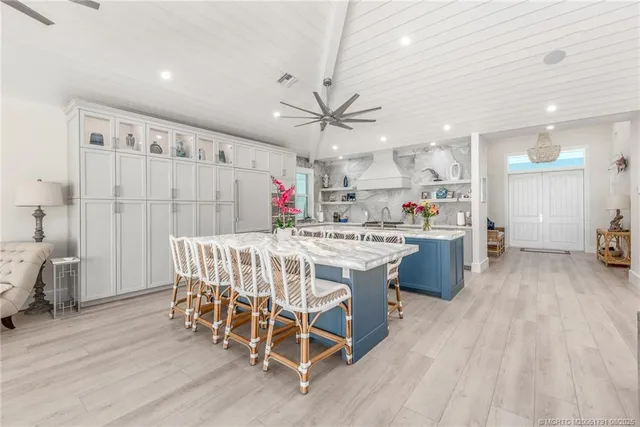 a kitchen with stainless steel appliances kitchen island granite countertop a table chairs sink and cabinets