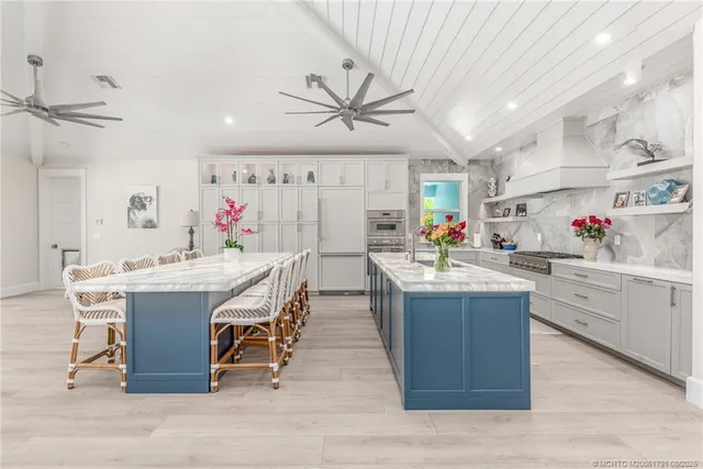 a kitchen with granite countertop a sink flowers in it and cabinets
