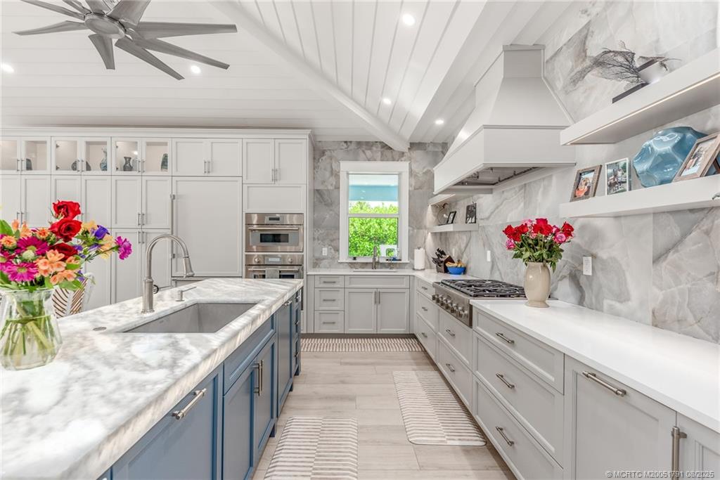 1879 Northwest River Trail Stuart, FL 34994 - Photo 7 of 25 a kitchen with granite countertop a sink flowers in it and cabinets