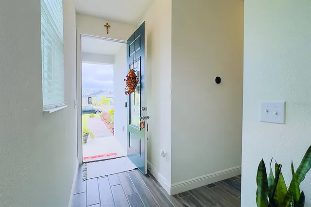a kitchen with a table chairs wooden floors and white stainless steel appliances