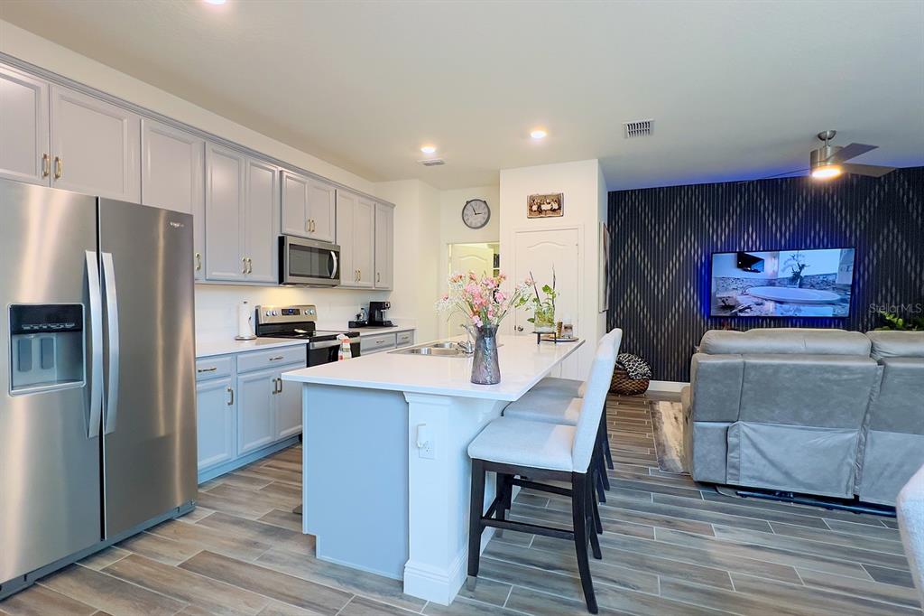 2755 Mdw Strm Way Clermont, FL 34714 - Photo 15 of 64 a kitchen with microwave a refrigerator and chairs