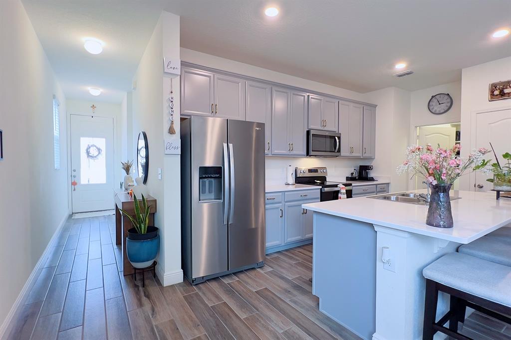 2755 Mdw Strm Way Clermont, FL 34714 - Photo 16 of 64 a kitchen with granite countertop a refrigerator cabinets and wooden floor