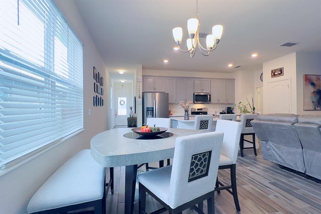 2755 Mdw Strm Way Clermont, FL 34714 - Photo 24 of 64 a view of a dining room with furniture and wooden floor