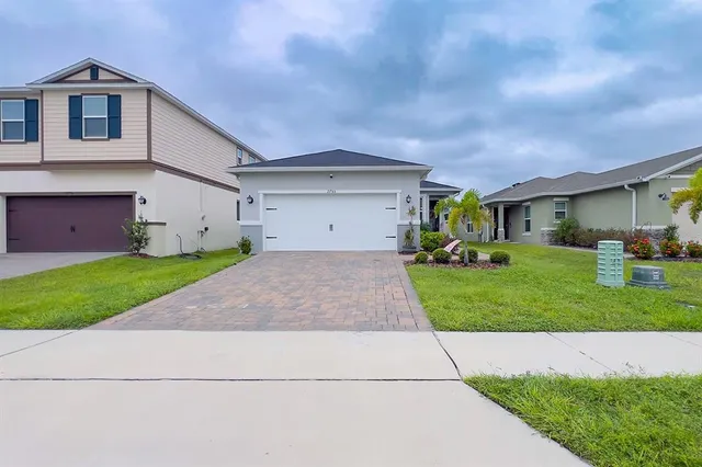 a front view of a house with a yard and garage
