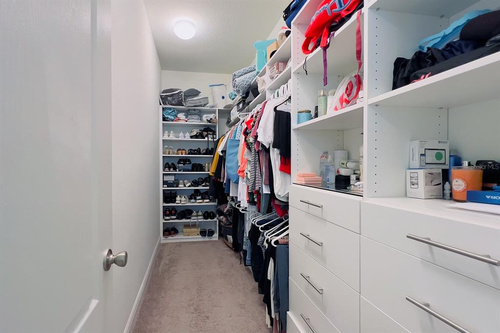2755 Mdw Strm Way Clermont, FL 34714 - Photo 35 of 64 a view of walk in closet with clothes and shoes