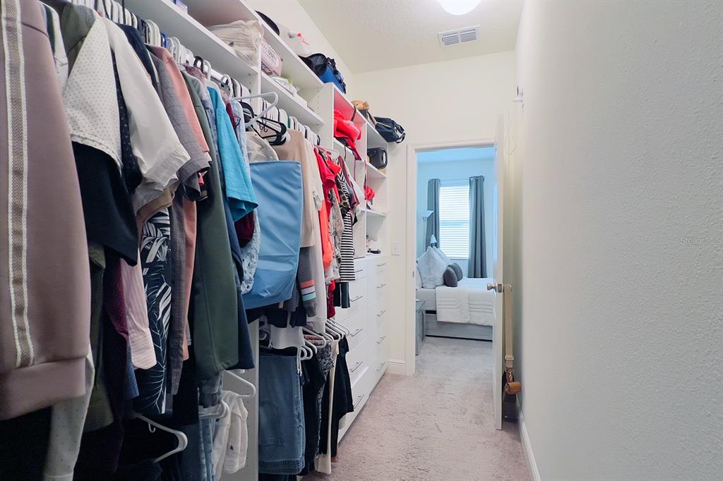 2755 Mdw Strm Way Clermont, FL 34714 - Photo 36 of 64 a view of walk in closet with clothes and shoes