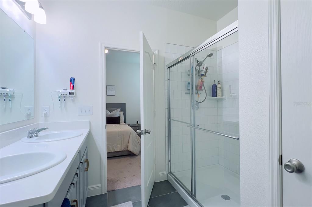 2755 Mdw Strm Way Clermont, FL 34714 - Photo 38 of 64 a en suite bathroom with a granite countertop sink and a mirror