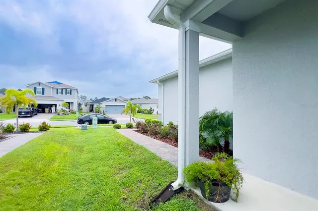 a view of a hallway with wooden floor and a bathroom