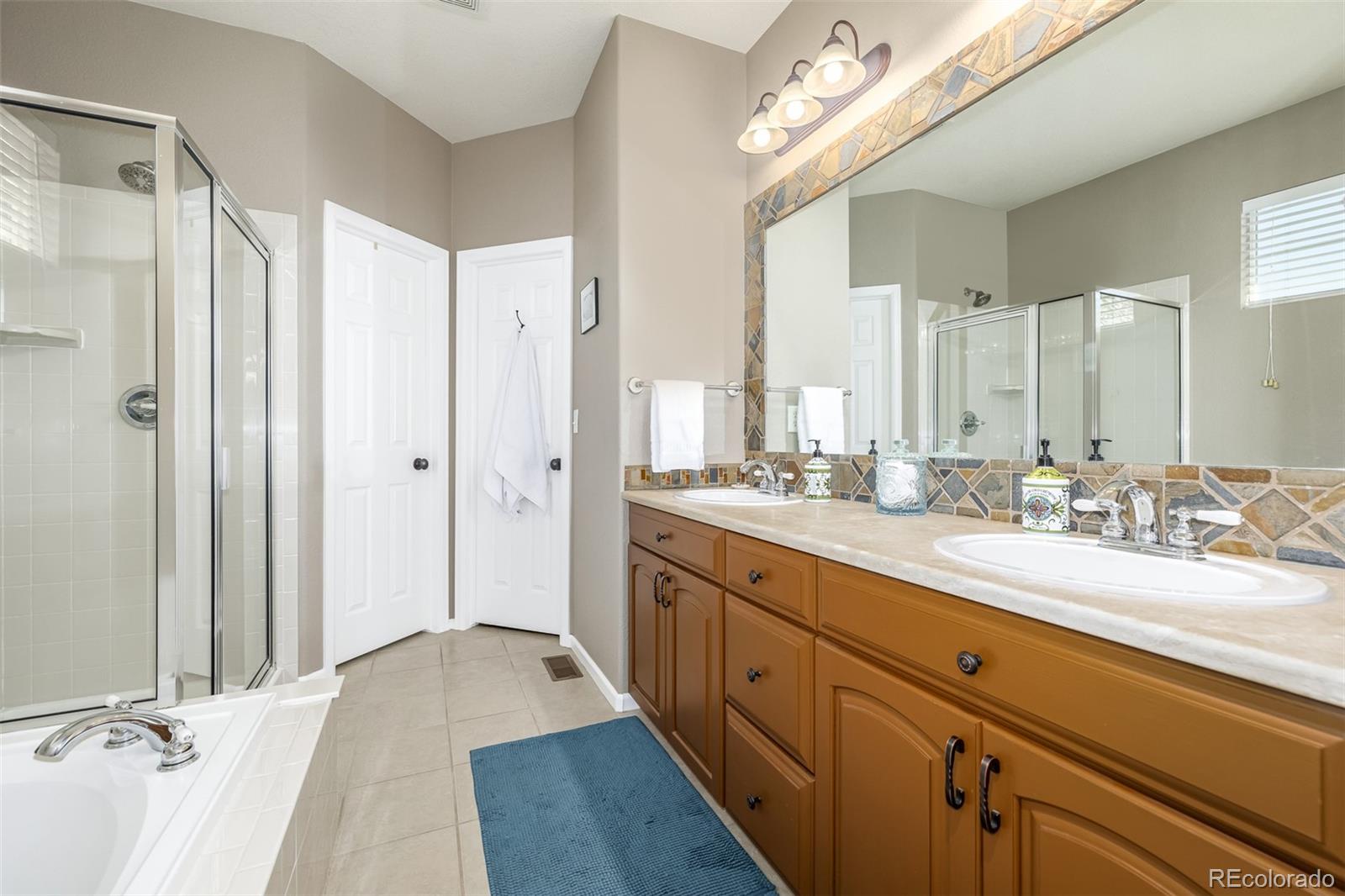 14704 Eagle River Loop Broomfield, CO 80023 - Photo 15 of 30 a spacious bathroom with a double vanity sink mirror and shower