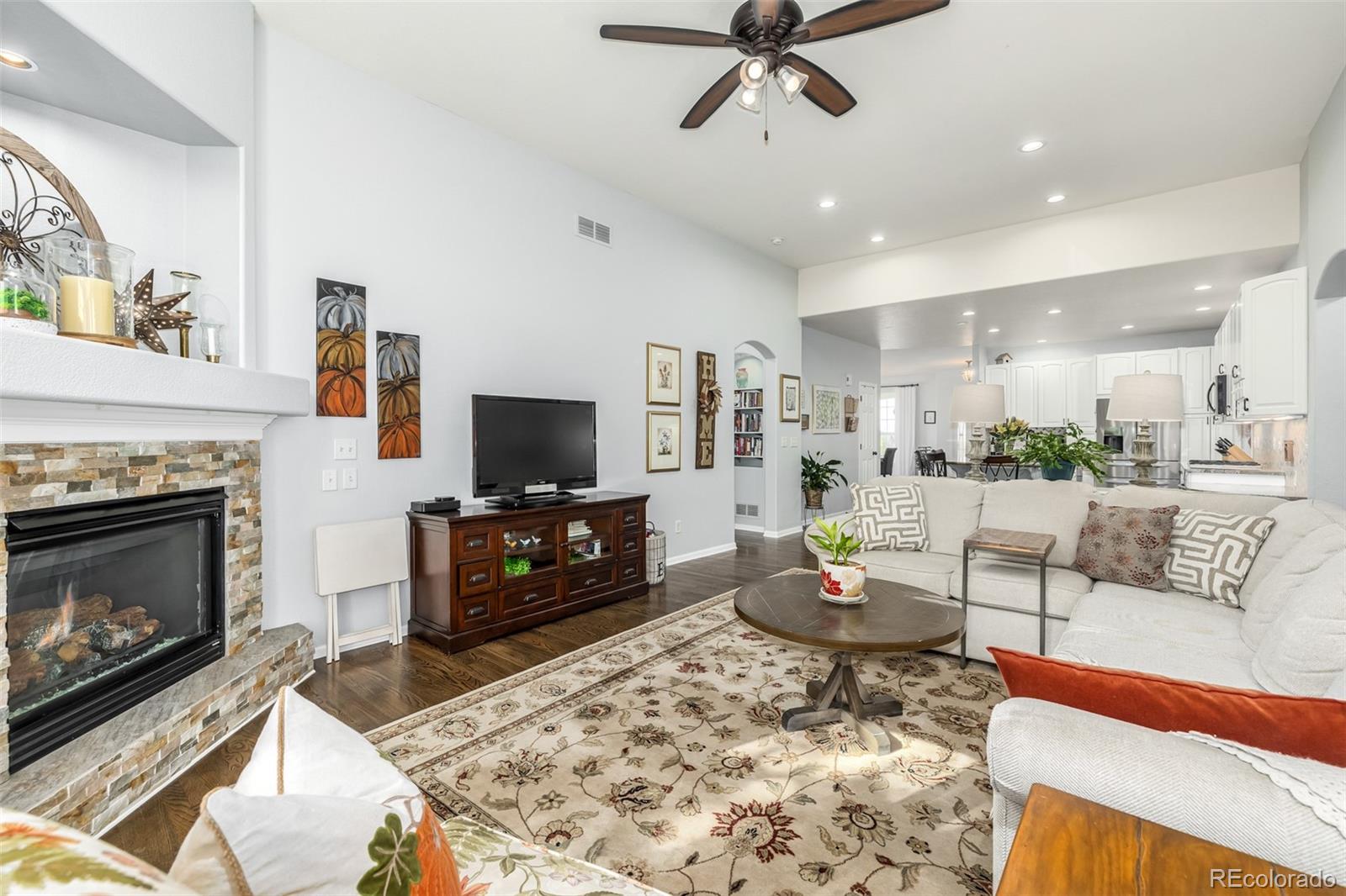 14704 Eagle River Loop Broomfield, CO 80023 - Photo 9 of 30 a living room with furniture a flat screen tv and a fireplace