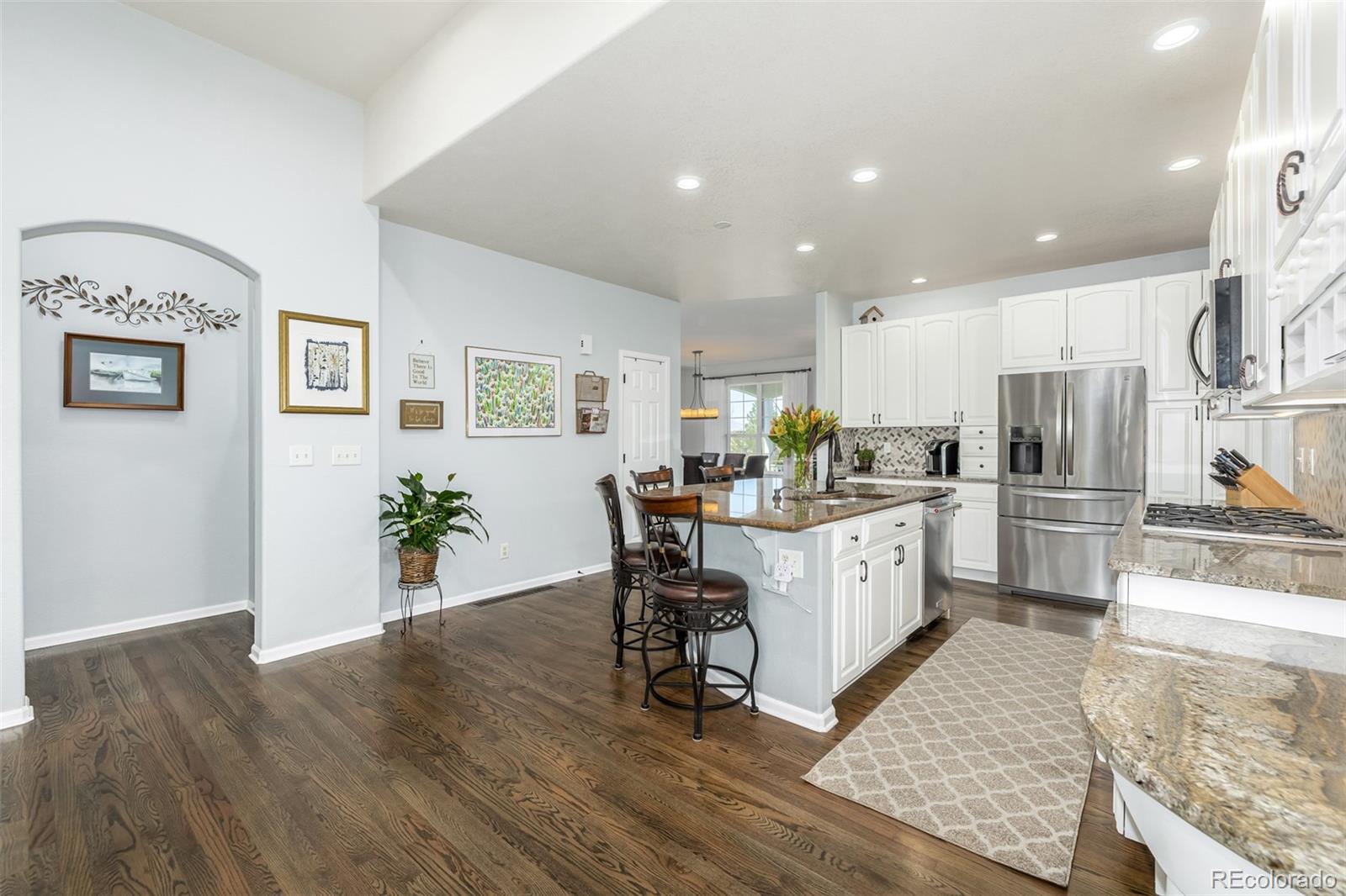 14704 Eagle River Loop Broomfield, CO 80023 - Photo 10 of 30 a kitchen with a refrigerator and wooden floor