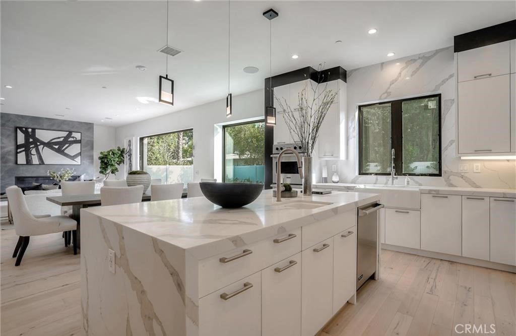 15926 Morrison Street Encino, CA 91436 - Photo 16 of 67 a view of kitchen island with stainless steel appliances kitchen island a sink dishwasher a dining table and chairs in it