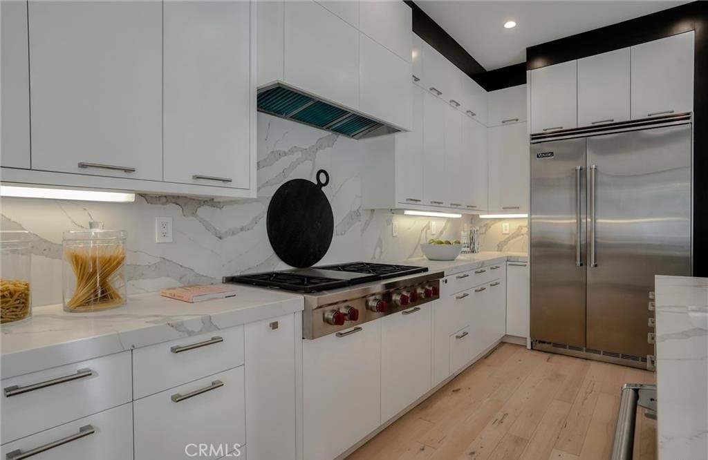 15926 Morrison Street Encino, CA 91436 - Photo 17 of 67 a kitchen with stainless steel appliances granite countertop a stove a refrigerator and a granite counter tops with white cabinets