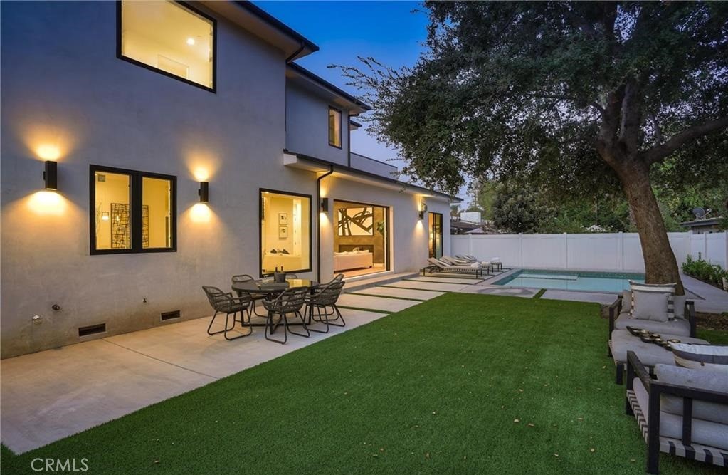 15926 Morrison Street Encino, CA 91436 - Photo 47 of 67 a view of a patio with table and chairs and potted plants with wooden fence