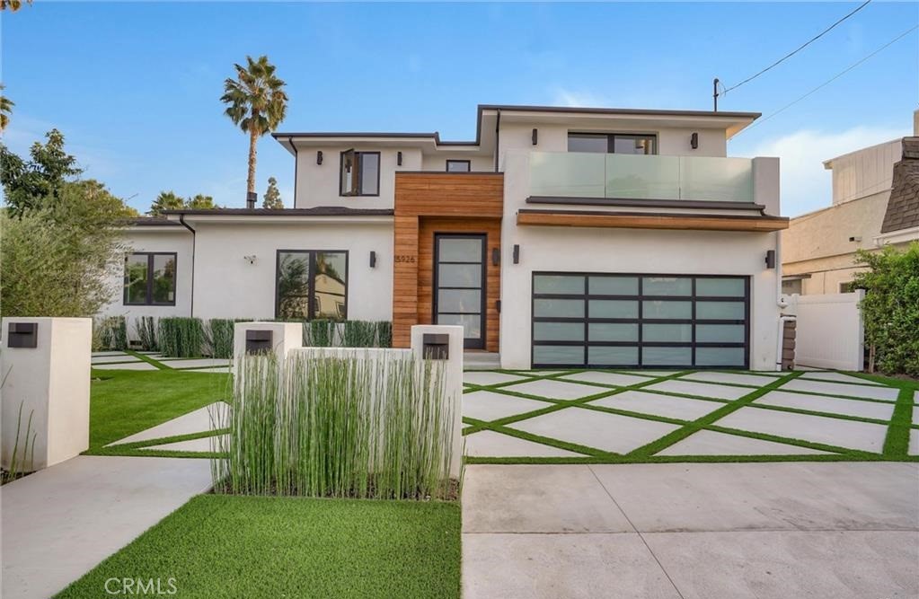 15926 Morrison Street Encino, CA 91436 - Photo 57 of 67 a front view of a house with a yard and garage