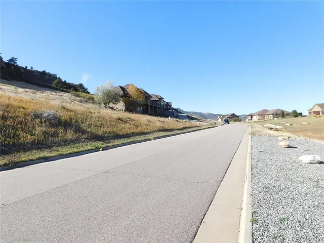 a view of a dry yard with wooden fence