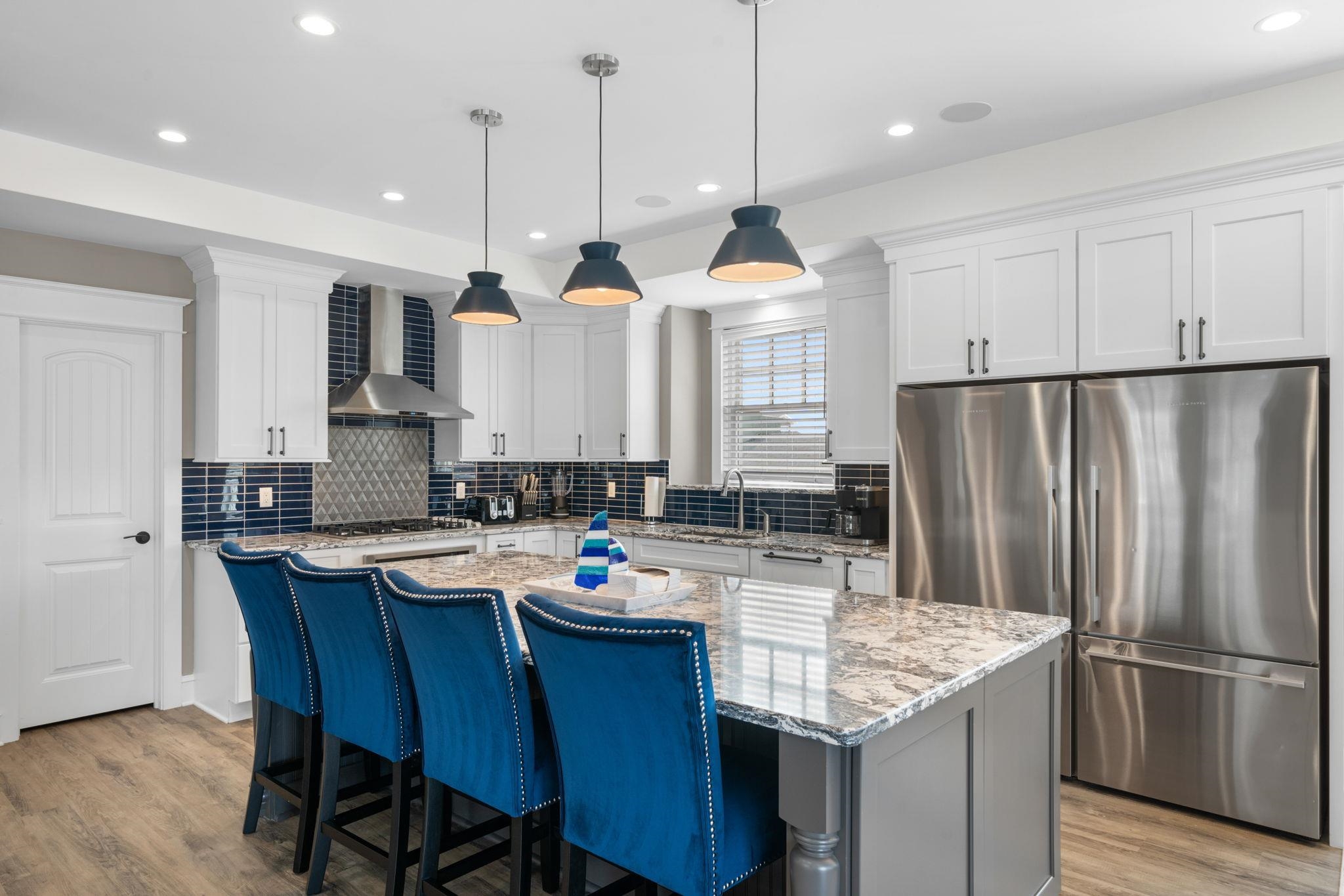 75 24th Street East Avalon, NJ 08202 - Photo 15 of 47 a kitchen with granite countertop kitchen island stainless steel appliances a refrigerator a sink a stove a dining table and chairs