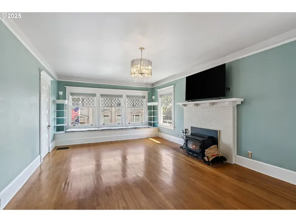 a view of empty room with fireplace and wooden floor