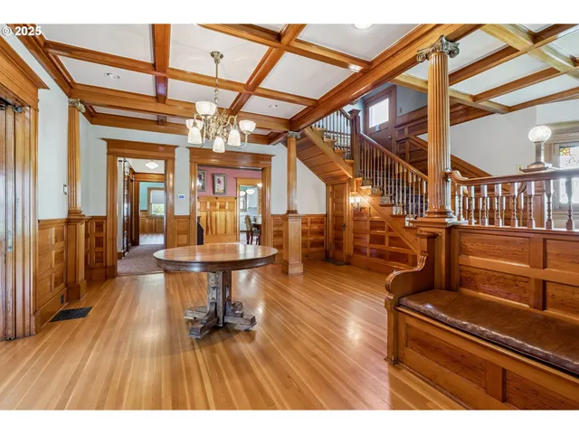 a living room with couches a dining table and chairs with wooden floor