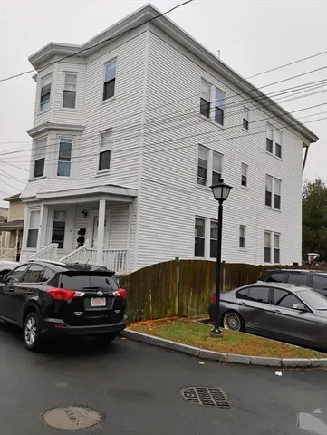 a car parked in front of a white house