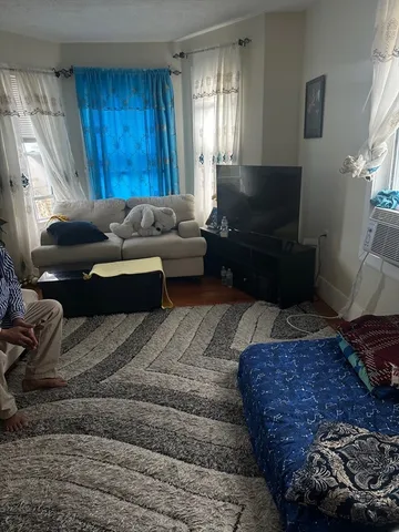 a living room with furniture wooden floor and a window