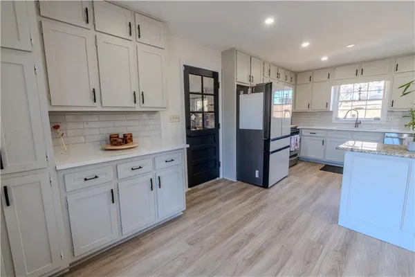 a kitchen with stainless steel appliances a refrigerator sink and cabinets