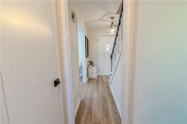 a view of a hallway with wooden floor and entryway