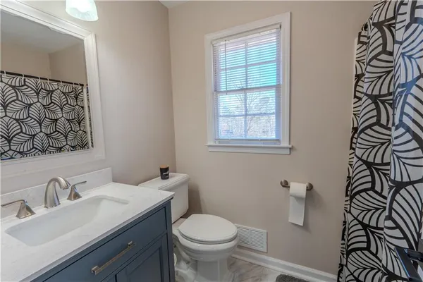 a bathroom with a granite countertop toilet sink and mirror