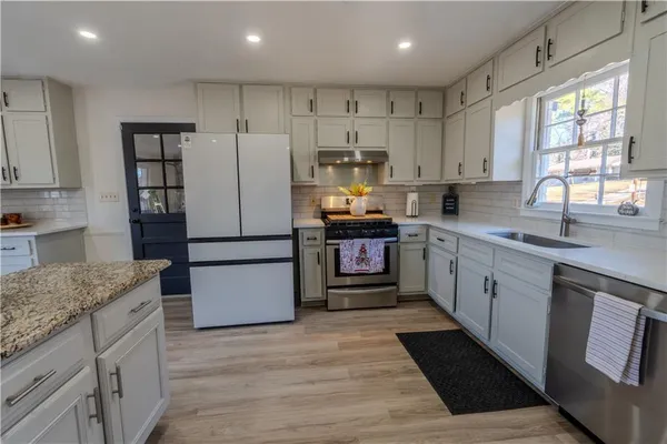 a kitchen with stainless steel appliances granite countertop a refrigerator sink and cabinets