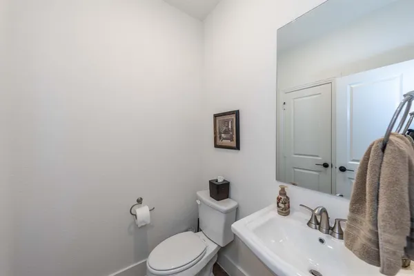 a bathroom with a toilet sink and mirror
