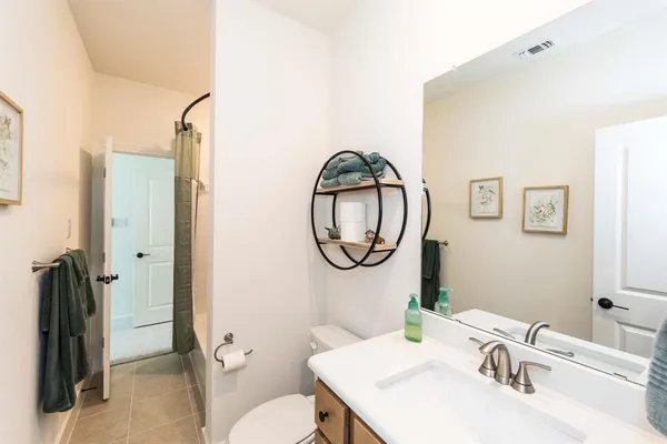 a bathroom with a sink a toilet and a mirror