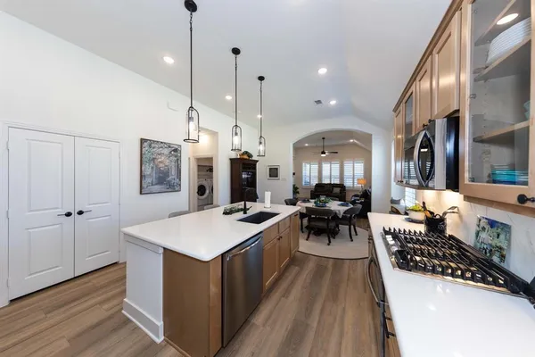a very nice looking dining room with a large center island and a wooden floor